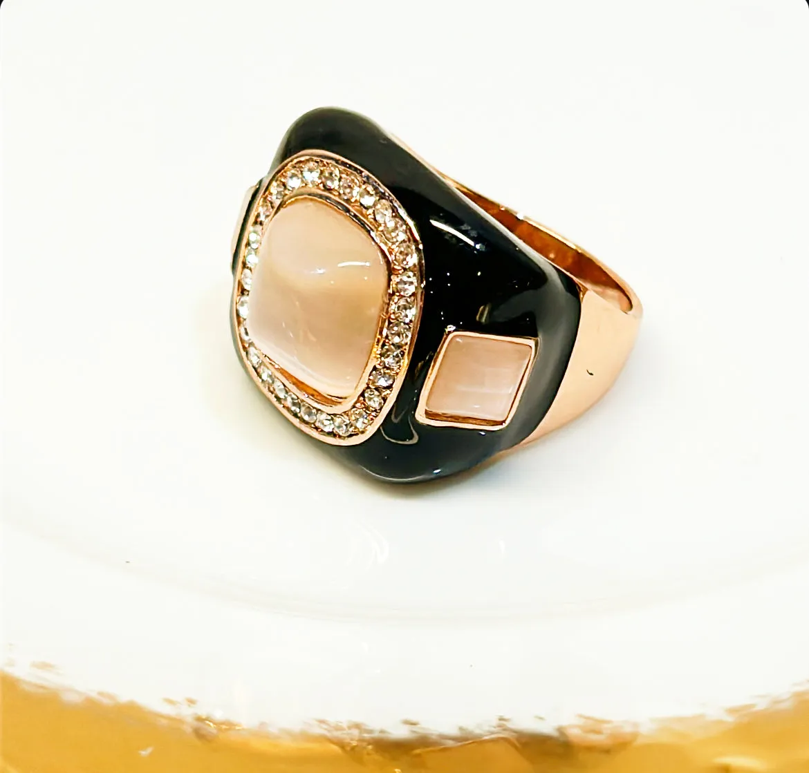 Large cocktail ring white black enamel accents set in a rose gold style metal.